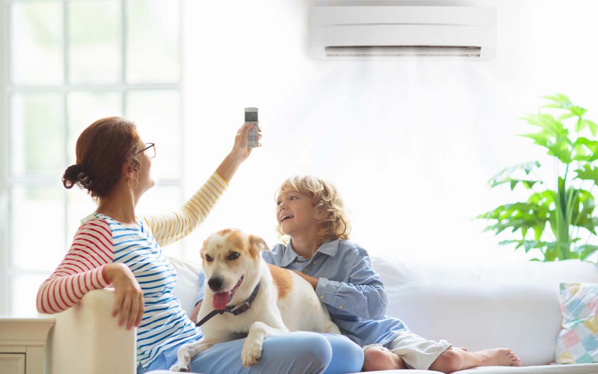 moeder zet airco aan in woonkamer met kind en hond